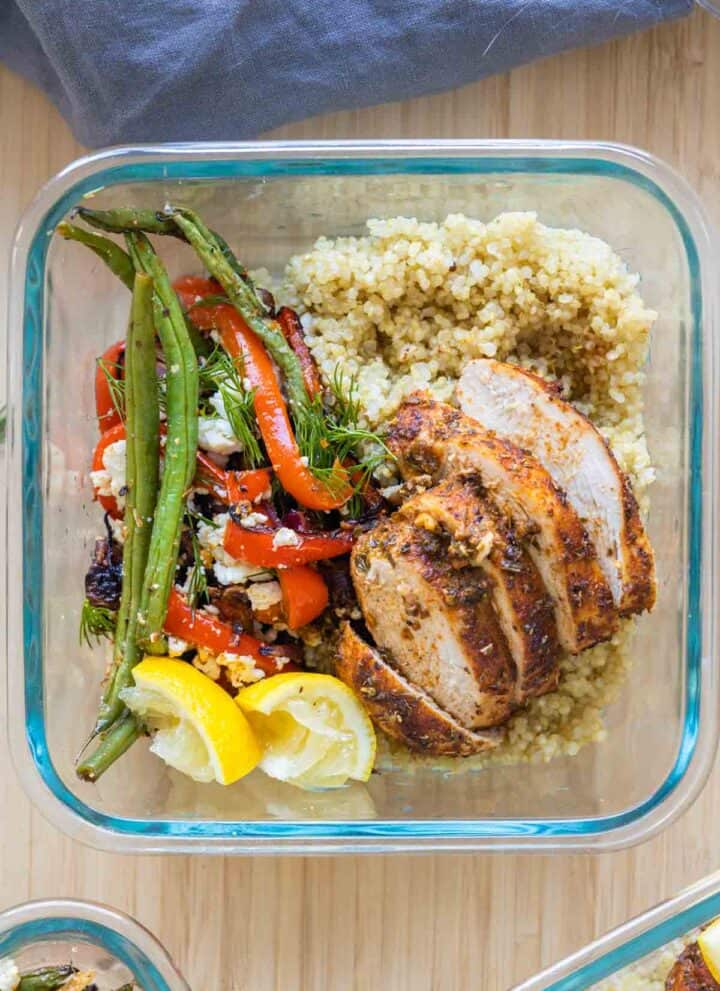 Square bowl with chicken, quinoa, and roasted vegetables.