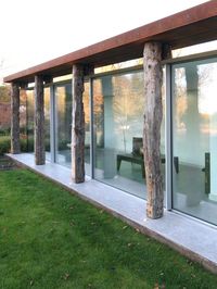 The metal framed glass doors sit behind timber posts to create the appearance of an open lean to structure. The glass doors are made from IQ's minimally framed glass door system with 21mm sightlines and floor to ceiling glass. The interlocks line up exactly with the timber posts so that they are hidden. A mirror above the glass doors allows the structure to be invisible. Click on the image to see more pictures of this barn conversion project.