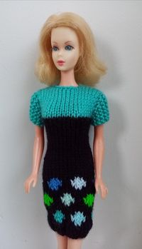 "This smart hand-knitted short-sleeved dress is knitted in dark navy blue and turquoise.  It has a polka dot motif on the skirt in shades of blue, green and turquoise.  It fastens at the back with two buttons.  This dress will look great on any 11\" fashion doll. Modelled by Carol. All my hand-knitted items are made in a smoke-free and pet-free home. Dress only - doll not included."