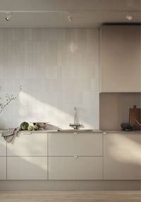 a beautiful contemporary taupe kitchen with sleek cabinets, taupe countertops and a backsplash, a white skinny tile backsplash is a very refined idea