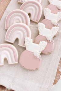 Boho-themed baby shower cookies featuring ruffled romper and rainbow shaped cookies in dusty rose and neutral royal icing colors.