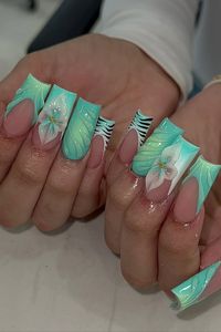 These nails are a work of art! The mint green base is accented with delicate flowers and zebra stripes, creating a unique and eye-catching design. The long, squared shape adds a touch of drama.