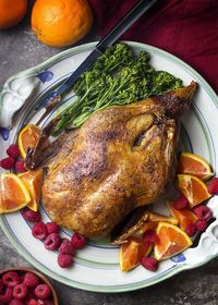 Crispy slow roasted duck is served with a raspberry orange port sauce. It's a simple, yet impressive, dinner recipe perfect for holidays and celebrations. Great for Christmas, Easter, Thanksgiving, and more! | justalittlebitofbacon.com #duckrecipes #holidayrecipes #christmasrecipes #easterrecipes #thanksgivingrecipes