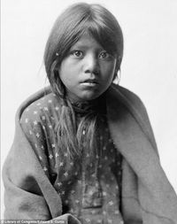 Innocence: A Taos girl is pictured looking straight into the camera, wrapped in a blanket. By Edwad S. Curtis, 1905.