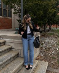 This outfit combines casual comfort with stylish elements, perfect for a relaxed day out. The look features a classic white tee paired with straight-leg jeans and a black cardigan. Black ballet flats and a black handbag add a touch of sophistication to this casual ensemble.  Photo credit by: @kerifay