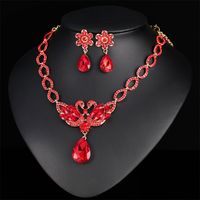 Make a bold statement with this elegant set that includes a sparkling necklace and earrings to match. Includes red crystal and 18k gold-plated swan necklace and matching floral earrings (three pieces total) Earrings: 0.47" W x 1.69" L Necklace : 16.14" L with 4.33" extender Pendant : 2.32" W x 2.56" L Lobster claw clasp 18k gold-plated copper / crystal / cubic zirconia