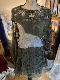 Green lacy fabric repurposed into a fairy costume for ritual, event, fun springtime summer attire. Three pieces- lace skirt, layered tank top, and lace shawl adorned with beaded abalone necklace detail. Shawl one size, tank small, skirt small-medium.