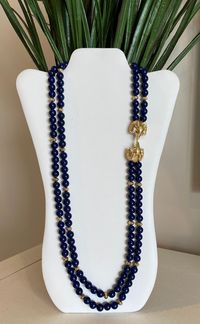 Kenneth Jay Lane's royal blue faux lapis beaded double strand necklace with double gold plated ram's heads encrusted with clear rhinestones and green rhinestone eyes. This was by designer Kenneth Jay Lane for Avon and in excellent condition. Please see pictures and video for description. Signed K.J.L. for Avon at clasp. Please visit my shop for more vintage jewelry: https://vintagetimejewelry.etsy.com/