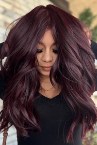 This alluring maroon hairstyle showcases luscious, flowing waves that bring a sense of casual grace and motion. The deep, rich maroon hue accentuates the hair's radiance and complements various complexions, making it an eye-catching choice for those desiring a daring yet stylish appearance. The style is adaptable - Click to see more of Mesmerizing Maroon Manes: 30 Stunning Hair Color Ideas to Elevate Your Look and follow us for more hairstyle ideas. // Photo Credit: Instagram @colors_by_amanda