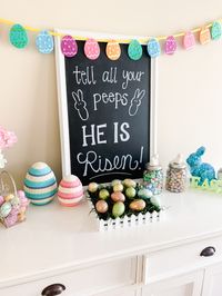 easter decorations surrounding chalk board sign that says "tell all your peeps he is risen!" Easter decor ideas for 2019! Easter chalkboard sign and DIY dollar tree easter decoration ideas! Bits of Bri Blog – a Blog by Brianna K #homedecor #easter #easterdecor #springdecor #spring #spring2019 #easter2019 #chalkboard #chalkboardart #springchalkboard #easterchalkboard #biblechalkboard #dollartree #DIY #dollartreeDIY #DIYdollartree #eastercraft #eastercrafts #easter2019 #springcrafts #springdecor