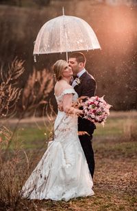 Romantic wedding photo of the bride and groom with an umbrella | Photo: Mike Zawadzki | Flowers: Pink Dahlia Floral Design #weddingphotography #weddingphotographer #njweddingvenue #njwedding #weddingphotoideas #rusticwedding #weddingflowers