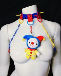 NOW MADE TO ORDER  PROCESSING TIME 3 WEEKS  ️ Baby clown vibes 🤡  A soft blue suede base ( adjustable 10-18 inches)  Yellow/red/blue stainless steel spikes ✖️✖️ Red suede strips connecting to plastic O rings connecting to plastic chains connecting to metal O rings and a cute clown plush centerpiece ||  ❤️❤️❤️ Ig @protectivechoke