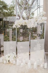 Sleek & modern glass escort card set-up for all white destination wedding at Solaz, A Luxury Collection Resort, Los Cabos in Mexico. Dream turned reality by Planner and Florist- Del Cabo Weddings and Photographer- Chard Photographer.