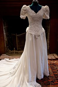 "Vintage 1980s wedding dress Puff sleeves Beaded, lace bodice V-neck High-quality polyester satin skirt with lace trim Large bow bustle Long, dramatic train Built-in loops and eye hooks to pin up train Zipper closure * small orangy stain on side of skirt Measurements: Waist- 27\" Upper hip- 33\" Hip- free Bust- 33\" Length (shoulder to front hem)- 60\" Length (shoulder to train hem)- 106\" Good condition!"