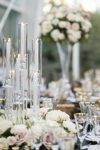 Candelabra surrounded by low white florals as reception table centerpiece for a summer wedding at Chihuly Museum Seattle.