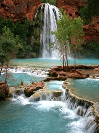 Havasu Falls  Plunging over majestic red rocks and pooling into milky, turquoise water, it's easy to see why Havasu Falls is one of the most photographed waterfalls in the world. It helps that the location is deep within breathtaking Grand Canyon National Park, where the waters eventually converge with the mighty Colorado River.