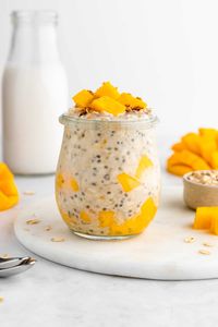 This mango overnight oats recipe is healthy, vegan, and gluten-free! It's an easy meal prep breakfast idea for busy families and on the go. They're made with yogurt, chia seeds, almond butter, and maple syrup. Since this is oatmeal in a jar, it's an easily transportable meal and great for work lunches! #overnightoats #overnightoatmeal #oatmeal #oatmealrecipe #oats #mango #mangoes #chiapudding #mealprep #veganbreakfast #healthybreakfast