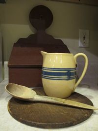 Yellow ware pitcher with early wooden spoon.