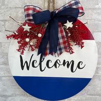 "This Patriotic Welcome round for your front door will look spectacular. It also can be used year round and it looks great anywhere it is placed. It's has a bold red, white, and blue color scheme and some pit berries, stars, and a bow to add the finishing touches. It can be used on Veterans Day, 4th of July, Memorial Day, and Labor Day.  This is a solid wood round and measures approximately 18\" in diameter."