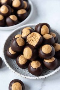 This Easy Buckeye Recipe makes creamy soft peanut butter centers that are mostly enrobed in rich dark chocolate, leaving just a circle of the filling exposed on top for that signature look of the famous Ohio icon. Buckeyes are a classic homemade candy that is popular at Christmas but can be enjoyed all year long! #buckeyes #candy #peanutbutter #darkchocolate #chocolate #homemade #recipe #Christmas #buckeye