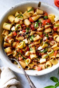 Serve this delicious Bruschetta Pasta Salad at your next BBQ or summer party. It’s the perfect light summer dish loaded with in-season plum tomatoes, mozzarella, basil, and a drizzle of balsamic glaze. #pastasalad #pasta #summerrecipes #bbqsidedish #vegetarian #healthyrecipes #weightwatchers