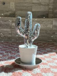 "a one of a kind eclectic statement piece to transform your home - the disco cactus ✨ this is the perfect piece to light up every room - especially when the sun hits & light reflects :) each disco cactus is handmade here in California. they are composed of mirror glass tiles that are individually placed to create the ultimate groovy statement home decor piece to your home. each piece is handmade so not all are identical. dimensions:  small : 9\" x 4.5\" large : 14\" x 5.5\" we can do custom orde