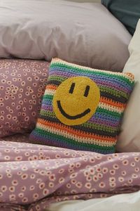 Bring positive vibes to your space with this crocheted throw pillow featuring a sweet, happy face. Crocheted by hand, each pillow may vary slightly from what's pictured here.Content + Care. 100% Cotton; 100% polyester Machine wash Imported Size. Dimensions: 18”l x 18”w