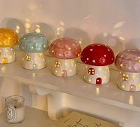 Add a touch of whimsy and warmth to any room with our Ceramic Mushroom Nightlight. This adorable nightlight features a dotted top mushroom cap and a charming little house stem, bringing a touch of nature indoors. But it's not just its cute appearance that makes it a must-have – it's also the warm yellow light that shines through the clear dots all over the ceramic, creating a soft and soothing ambiance. Available in four delightful colors – pink, purple, blue, and yellow – our Ceramic Mushroom Nightlight is the perfect addition to any nursery, bedroom, or living room. It's not just a functional piece, but a decorative one too, adding a playful and inviting element to your home decor. But our Mushroom Nightlight is more than just a pretty face. Its ceramic material ensures durability and lo