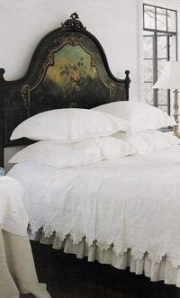 crisp white bed linens and white walls contrast beautifully with the dark painted headboard