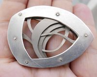 "Abstract sculptural brooch by Douglas Wunder. Made from titanium. Artist signed and dated 1995. Measures 2 1/8\" x 1 1/2\" x 1/4.\" Condition - structurally excellent, no repairs. Slight bend to one of the bottoms layers - see photos."