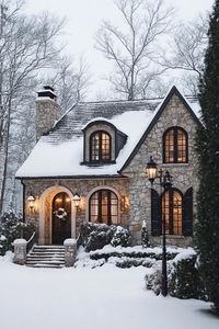 French cottage house with stone siding snow on the roof arched entry with steps clean off snow snowed in front yard lamp posts surrounede with. The cozy secrets of Winter Wonderland houses, where snowflakes meet architectural marvels and your dream home comes to life.