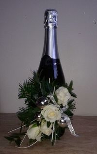 A lovely gift idea.  A fresh flower arrangement on a bottle of champagne.