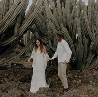 Wild cactus wedding with the beautiful just married couple.  The groom is wearing a hand made Australian wool Calloway Ash hat next to his bride in her layered lace boho wedding dress.