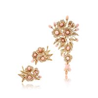 Comprising: a brooch designed as a floral spray supporting an articulated pendant, featuring oval, drop- and button-shaped conch pearls, enhanced with brilliant- and single-cut diamonds, signed Boucheron Paris, partial maker's marks for Boucheron, case stamped Boucheron; and a pair of ear clips of similar design, unsigned, French maker's mark; French assay marks for gold.Accompanied by a gemmological report.