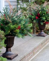 Classic Christmas front door with evergreen wreath and lush urn planters