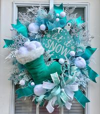 Icy winter snowflake wreath with a Santa boot overflowing with snowballs and snowflakes. Adorned with a wood soon that reads, Let it Snow. This wreath is perfect for Christmas and all throughout the winter season.