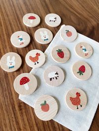 Wooden Memory/Matching Game: Spring Animals and Fruit Includes 14 hand painted wooden circles, each measuring 1.5" inches: - 2 Bunnies - 2 Sheep - 2 Chickens - 2 Geese - 2 Mushrooms - 2 Strawberries - 2 Oranges Your set comes in a muslin bag for safe-keeping!