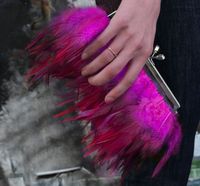 Hot pink two-toned  hackle feather clutch with jeweled clasp with row of rich hot pink feathers with satin ribbon rim. Both sides of the clutch are adorned with feathers. There are also metal pegs on the bottom to minimize dirt when it is resting, waiting to be picked up again. A metal clasp, silver in color, has crystal detail. Comes with metal chain strap that can tuck away inside the purse or be detached. Purse measures 9.5" (at it's widest part) x 4.875" (from clasp to peg) x 2.375" deep (at it's thickest part). Perfect to store your essentials for a glitzy night out, a dance, your bridal party, or to add fun to an ordinary outfit. Also a small pocket inside the satin lining, perfect for an ID and credit card. I operate my shop by myself. In my shop, I incorporate vintage buttons, fabr