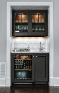 Living room features snack bar with glass-front upper cabinets and black lower cabinets paired with gray granite countertops and subway tiled backsplash.