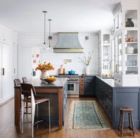 Upper cabinets are painted Benjamin Moore Calm and lower cabinets and island are painted Ocean's Floor. Design by Studio Dearborn