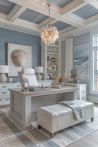 Chic coastal home office with minimalist white furniture, accented by navy blue decor and striped patterns, a statement shell chandelier overhead, and a plush area rug in hues of beige and soft gray, creating a sophisticated yet relaxed atmosphere perfect for productivity