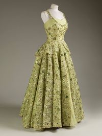 This pale green crinoline gown was worn by Her Majesty The Queen for a dinner at the British Embassy in Washington, D.C. in 1957, during her first visit to the United States of America. Designed by Norman Hartnell, the dress is made of silk chiffon and lace embroidered with sequins, pearls, beads and diamanté.