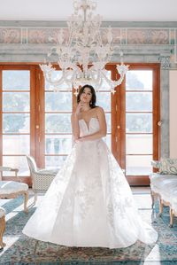 La Femme by Anne Barge Bridal - Lace ballgown wedding dress of oversized floral Chantilly lace with sequined appliqués and deep V neckline. For the modern romantic bride.