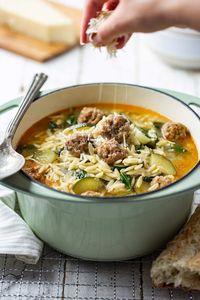 This Italian Meatball & Orzo Soup is everything you want in a Fall soup, and more! A beautifully flavourful broth. Mild Italian meatballs. Pasta. Zucchini. Spinach. All perfectly brought together with a generous sprinkling of freshly grated Parmesan cheese. #FallSoup #OnePotSoup #EasySoup #MeatballSoup #ItalianSoup #ItalianMeatballSoup