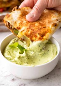 Quesadilla being dipped into Avocado Sauce