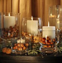 Thanksgiving decorating with acorns, large glass candle holders, and white pillar candles. Did you guys know that you need to either bake your acorns or put them in a freezer for a day before you put them out on display? Apparently there's a type of worm that likes to live in acorns and they can crawl out of your display! #ew #goodtoknow #lifehack