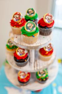 Rev up for a sweet ride! Our Mario Kart party features Mario cupcake rings on a three-tier farmhouse style white cupcake stand. Let the fun (and the cupcakes) race to the finish! 🏁🍰 #MarioKartParty