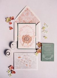 Pink and sage flat lay with wedding invite and rings with floral details from a PNW summer wedding.