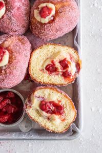 Brioche Doughnuts with Vanilla Bean Pastry Cream and Roasted Strawberry Filling. Roasting strawberries brings out the most amazing sweet flavour, which pairs so perfectly with the smooth vanilla bean pastry cream and fluffy brioche doughnut dough which is rolled in a freeze dried strawberry sugar. #briochedoughnut #strawberrydoughnut #roastedstrawberry