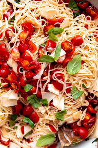 Marinated Tomato Pasta is the ultimate summer dinner: minimal cooking required & made with in-season ingredients! Start by quickly marinating fresh cherry tomatoes in olive oil with shallots, garlic, & fresh basil, creating a no-cook fresh tomato sauce with light & bold flavor. From there, toss in warm pasta & shaved parmesan. Ready in 30 minutes or less! Meatless, & easily vegetarian, vegan, & dairy-free. #marinatedtomatoes #freshtomatopasta #freshtomatosauce #easydinnerideas #pastarecipes